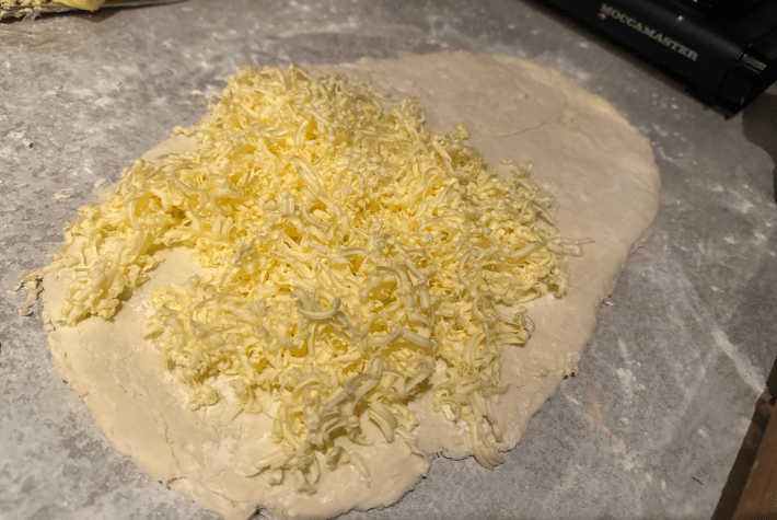 a pile of grated butter on some dough